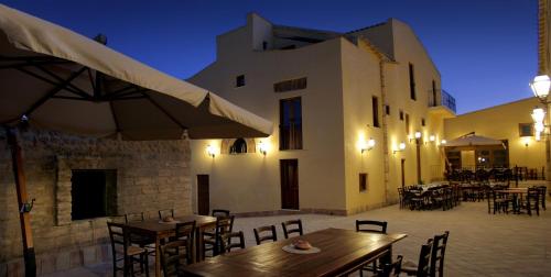 a patio with tables and chairs and a building at Agriturismo Passo dei Briganti in Agrigento