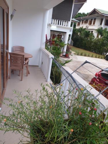 a balcony of a house with a table and chairs at La Maison Hibiscus Self Catering Accommodation in Beau Vallon