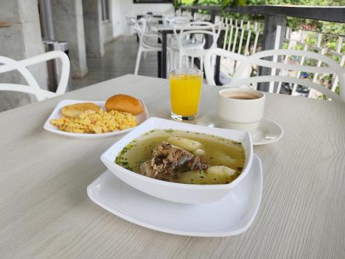 a table with a bowl of soup and a plate of food at Hotel Centauros del Llano in Villavicencio
