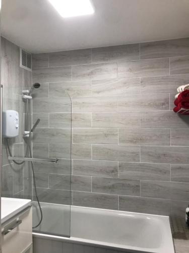 y baño con ducha y bañera. en Towan Beach Holiday Flat, en Newquay