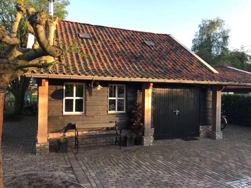 a wooden cabin with a bench in front of it at Farmhouse 'het Plakje' in Bemmel