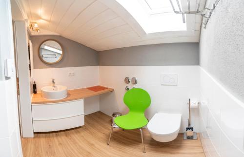 a bathroom with a green chair and a sink at Zinsers Bergliebe in Inzell