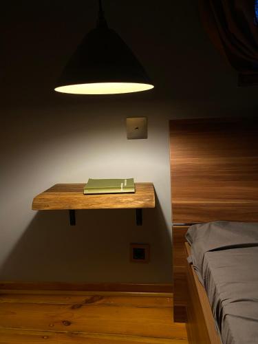 a table with a book on it next to a bed at Rakstvežu apartamenti in Liepāja