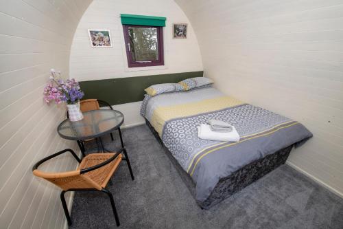 a small bedroom with a bed and a table at Seaways glamping, English Oak in Great Driffield