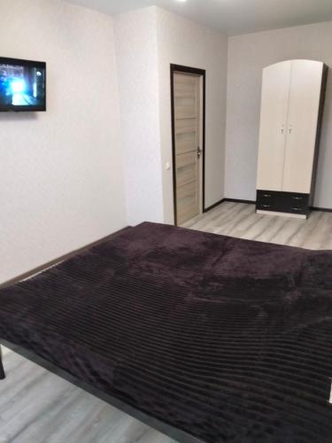 sypialnia z łóżkiem i telewizorem na ścianie w obiekcie Квартира в ЖК Атриум w mieście Irpień