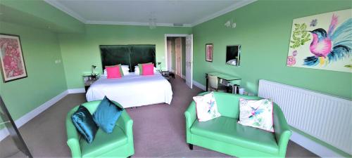 1 dormitorio verde con 1 cama y 2 sillas en Patricks Boathouse, en Swansea