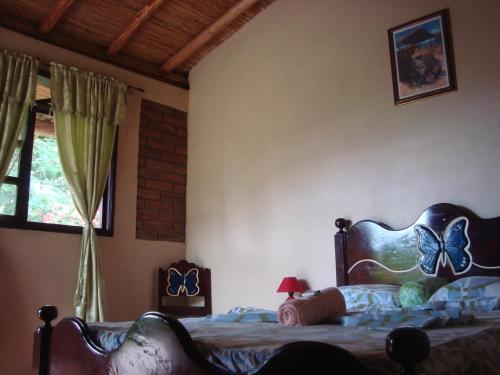 a bedroom with a bed with butterflies painted on it at Ecolodge Blue Morpho in Cárdenas