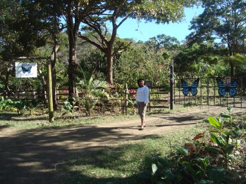 a man walking down a path in front of a fence at Ecolodge Blue Morpho in Cárdenas