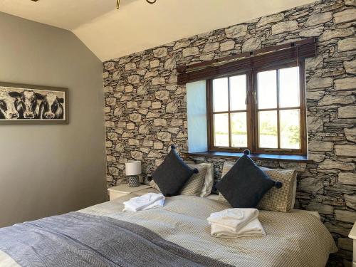 1 dormitorio con 1 cama con pared de piedra en The Mary Tavy Inn en Tavistock