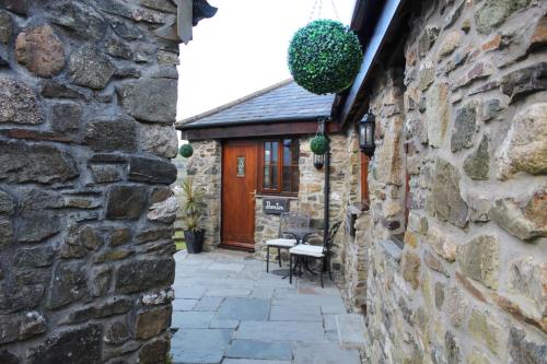 a stone house with a courtyard and a wooden door at The Mary Tavy Inn in Tavistock