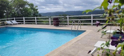 a swimming pool with a white fence next to it at Le Clos Des Etoiles in Le Bugue