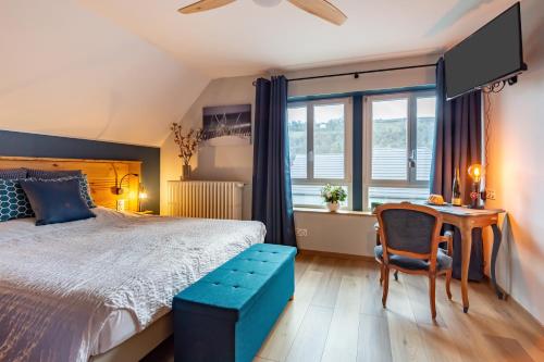 a bedroom with a bed and a table and a chair at À la Vieille Faïence in Wintzenheim