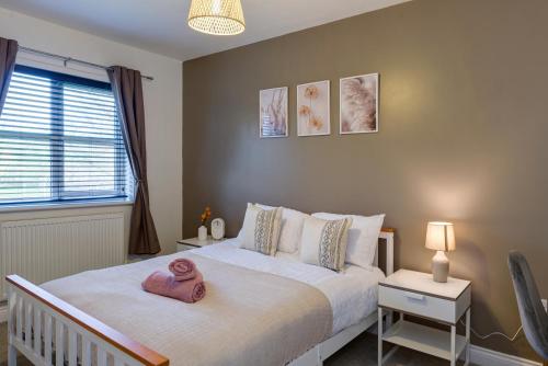 a bedroom with a bed with a pink towel on it at Comfortable 3 bed home LINCOLN in Lincolnshire