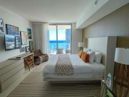 een slaapkamer met een bed en uitzicht op de oceaan bij Private apts over the beach - Resort & Residence building in Hollywood