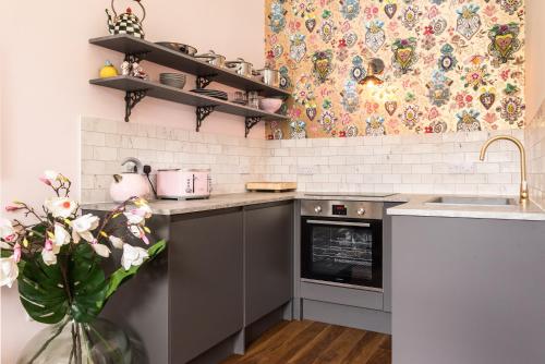 a kitchen with a sink and a stove at Newly renovated stunning apartment in Stockbridge in Edinburgh