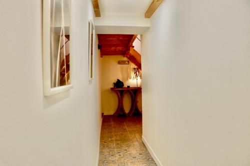 a hallway with a white wall and a table at Constância Guest House in Constância