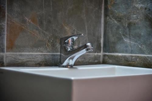 a bathroom sink with a faucet on top of it at Iraklis Apartments in Stalida