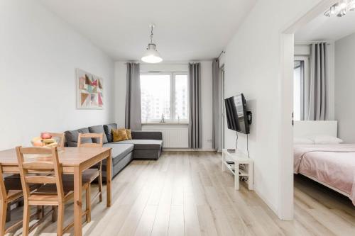 a living room with a couch and a table and a bed at Chill Apartments Airport Apartments in Warsaw