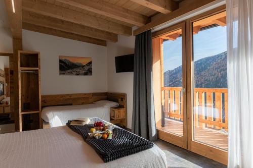 a bedroom with a bed and a large window at Albergo Alpino in Vermiglio