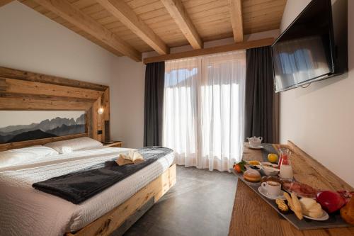 a bedroom with a bed with a tray of food on it at Albergo Alpino in Vermiglio