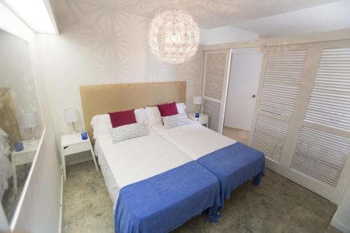 una camera con un grande letto e un lampadario a braccio di Centro Colón a Madrid