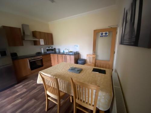 a kitchen with a table and chairs in a room at Little Ship Inn Rooms in Invergordon