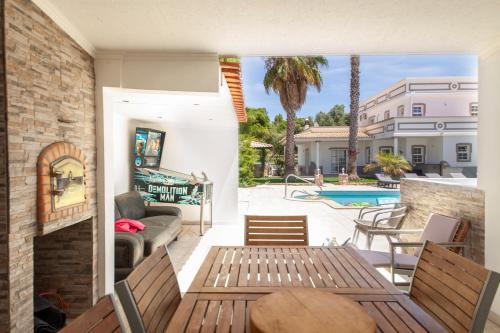 a patio with a table and chairs and a pool at Casa Petit Paraiso in Lagoa