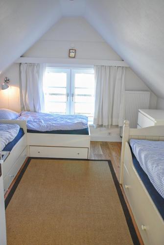a bedroom with two beds and a window at Groot Huus in Norderney