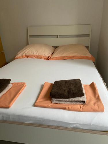 - un lit avec 2 couvertures et 2 oreillers dans l'établissement Apartmani Antonio 1, à Brodarica