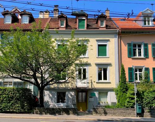 ein großes Haus mit einem Baum davor in der Unterkunft CityLodge St Gallen - 2 min to Marktplatz in St. Gallen