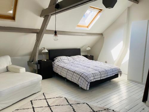 a bedroom with a bed and a window and a couch at O-Sea House: herenwoning in Belle Epoque wijk te Oostende in Ostend