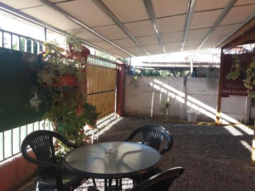 a patio with a table and chairs and a fence at Alojamiento Valle Verde in Isla de Maipo