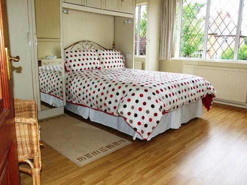a bedroom with a bed with a polka dot bedspread at Gayton Bed & Breakfast in Hampton in Arden