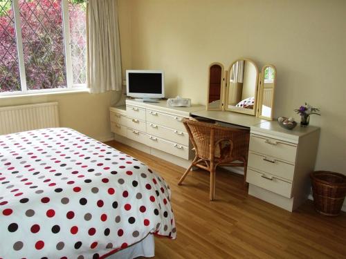 a bedroom with a bed and a desk with a television at Gayton Bed & Breakfast in Hampton in Arden