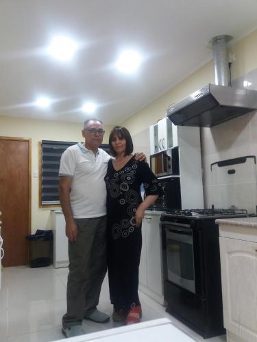 a man and a woman standing in a kitchen at Alojamiento Valle Verde in Isla de Maipo