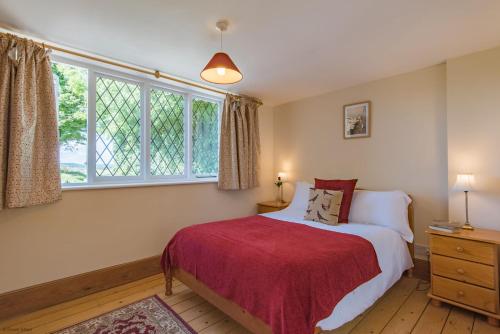 ein Schlafzimmer mit einem Bett mit einer roten Decke in der Unterkunft Pheasants Lodge by Bloom Stays in Canterbury