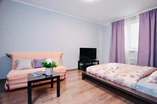 モスクワにあるKvartiraSvobodna - Apartment at Gerasima Kurinaのリビングルーム(ベッド1台、ソファ付)