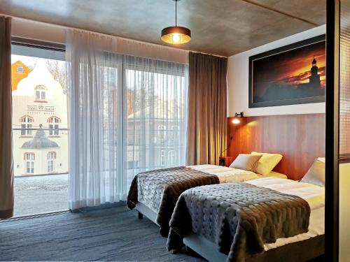 een hotelkamer met 2 bedden en een groot raam bij Paderewskiego 9 Aparth in Leszno
