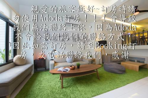 a living room with a coffee table and a wall with writing at 極簡旅行民宿 Simple Travel B&B in Wujie