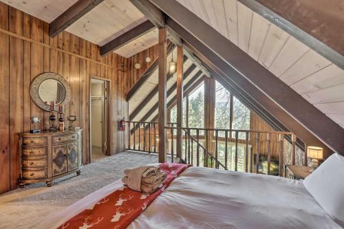 a bedroom with a large bed in a room with wooden walls at Quaint Cabin Retreat about 4 Mi to Arrowhead Lake in Lake Arrowhead