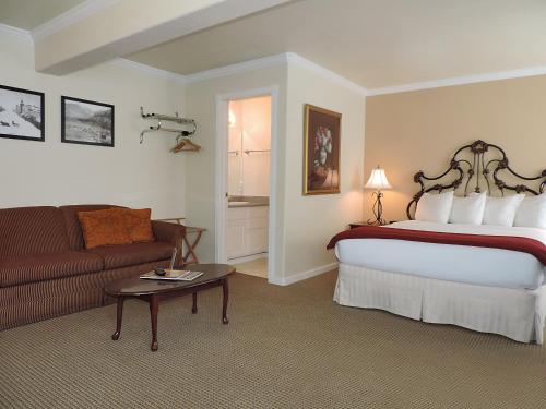 Habitación de hotel con cama y sofá en The Victorian Inn, en Telluride