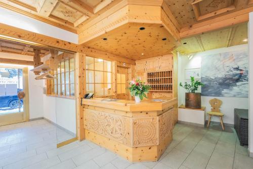 a large room with a kitchen with wooden walls at Hotel Corvatsch in St. Moritz