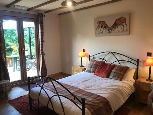 sypialnia z łóżkiem z czerwonymi poduszkami w obiekcie Pine Chalet w mieście Muir of Ord