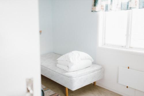 um quarto branco com uma janela e um banco com toalhas em Lappland Pro Natur em Åsele