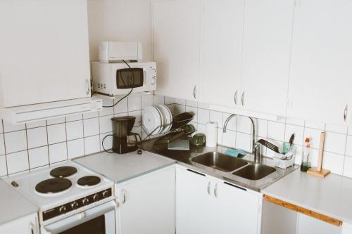 uma cozinha branca com um lavatório e um fogão em Lappland Pro Natur em Åsele