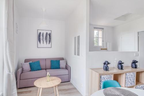 a living room with a purple couch and a table at Freedomus Marne-la-Vallée "Le 12" in Crecy la Chapelle