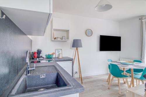 a kitchen with a sink and a table at Freedomus Marne-la-Vallée "Le 12" in Crecy la Chapelle