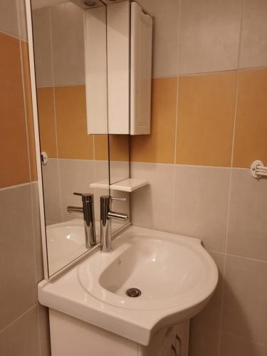 y baño con lavabo blanco y espejo. en GÎTE Le Calou Pilon, en Cilaos