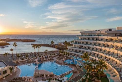 アデへにあるHOVIMA La Pinta Beachfront Family Hotelのプールと海を望むリゾートの空からの景色を望めます。