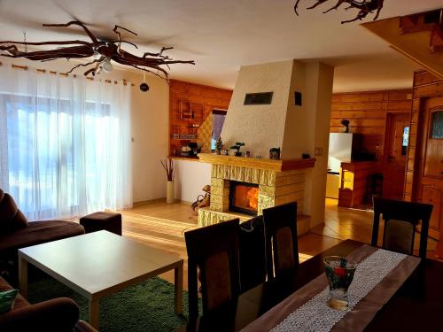 uma sala de estar com uma lareira e uma mesa em Forest House em Lubomierz